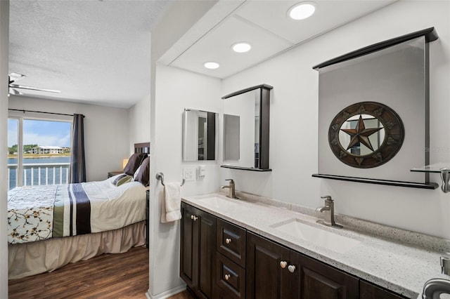 26290 Rampart Blvd Unit D, Punta Gorda, FL 33983 - bathroom featuring connected bathroom, wood finished floors, double vanity, and a water view