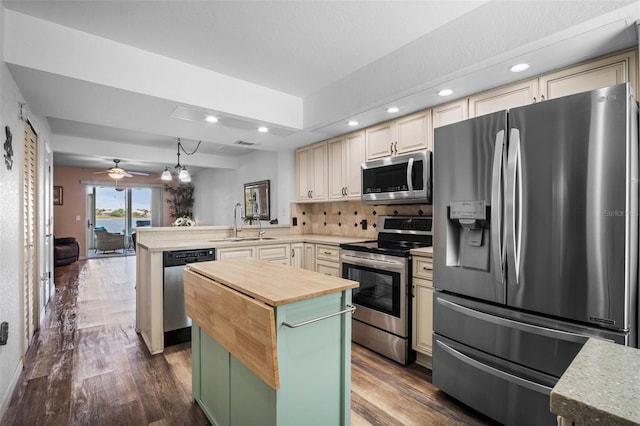 26290 Rampart Blvd Unit D, Punta Gorda, FL 33983 - kitchen featuring stainless steel appliances, cream cabinetry, a peninsula, butcher block countertops, and a kitchen island