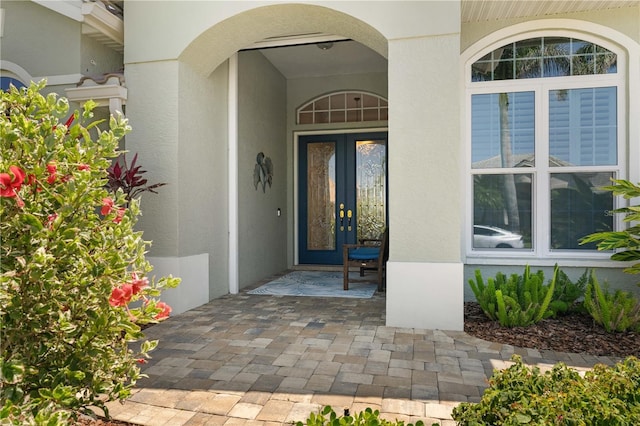 entrance to property featuring stucco siding and french doors