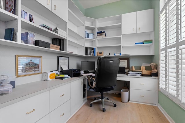 office space with baseboards, light wood-style flooring, and built in study area