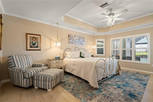 bedroom featuring wood finished floors, crown molding, and baseboards