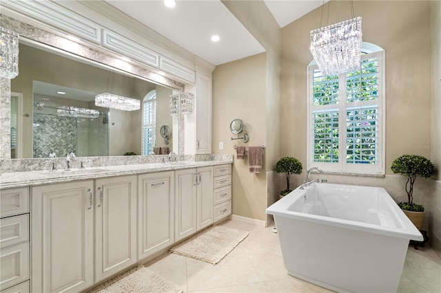 bathroom with a stall shower, an inviting chandelier, a sink, and double vanity