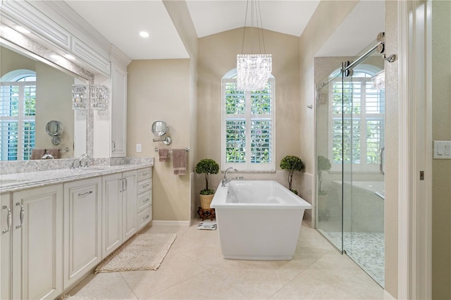 full bath with tile patterned floors, a freestanding bath, vanity, a stall shower, and a notable chandelier