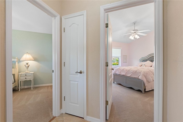 corridor featuring light carpet and baseboards