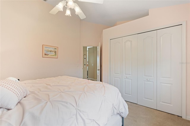bedroom with a ceiling fan, light carpet, lofted ceiling, and a closet