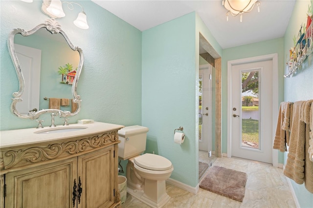 full bath featuring a shower stall, toilet, a textured wall, and vanity