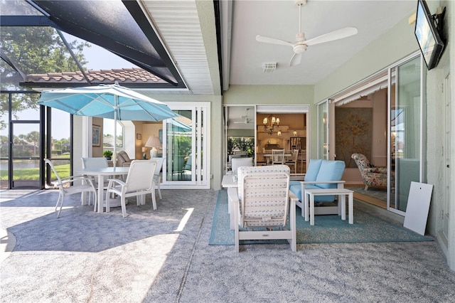 view of patio / terrace with visible vents, a ceiling fan, glass enclosure, and outdoor dining area