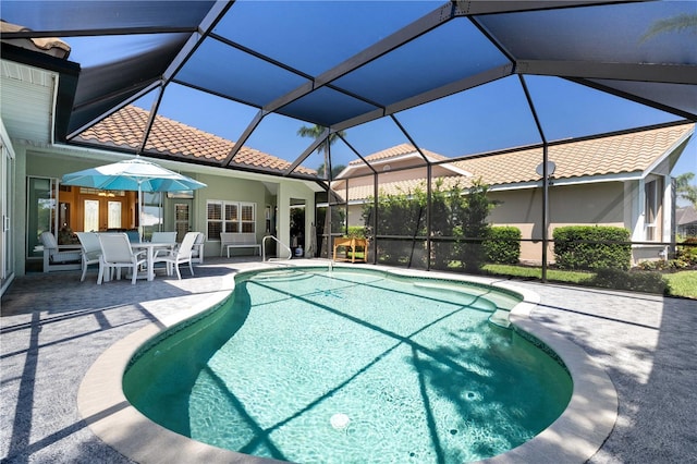 pool with a patio and glass enclosure