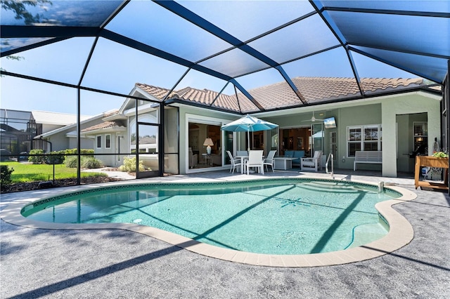 outdoor pool featuring a ceiling fan, a patio, and glass enclosure