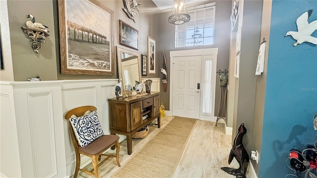 entrance foyer featuring light wood finished floors and a wainscoted wall