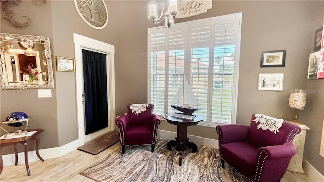 sitting room featuring wood finished floors, baseboards, and an inviting chandelier