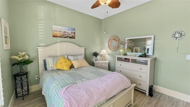 bedroom featuring ceiling fan, wood finish floors, and baseboards