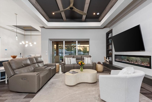 living area with a high ceiling, a raised ceiling, a large fireplace, a ceiling fan, and recessed lighting