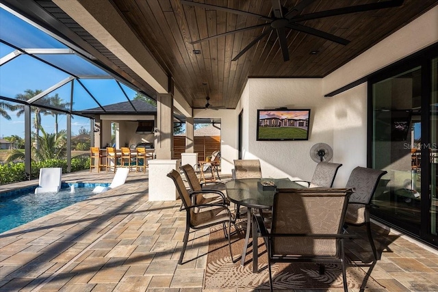 view of patio / terrace featuring a lanai, ceiling fan, outdoor dining space, and an outdoor pool