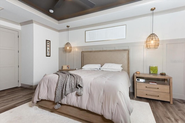bedroom featuring a decorative wall and wood finished floors
