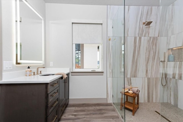 full bath featuring vanity, walk in shower, and wood finished floors