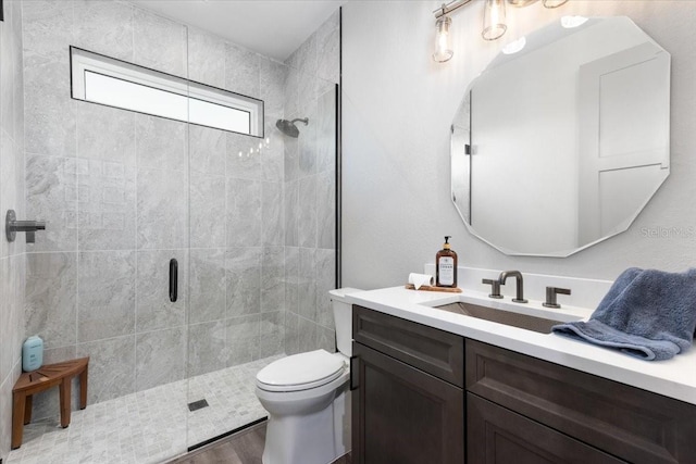 bathroom featuring vanity, wood finished floors, toilet, and a shower stall