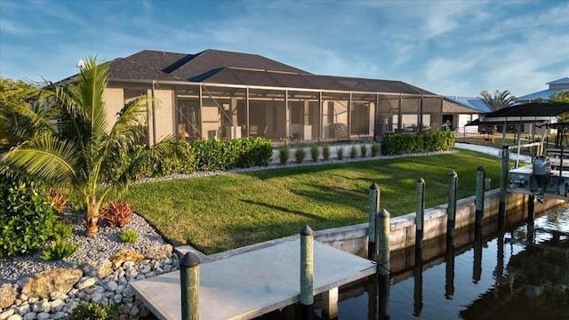 back of property featuring glass enclosure and a yard