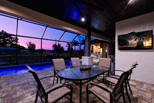 view of patio / terrace featuring a hot tub, a lanai, an outdoor pool, and outdoor dining space