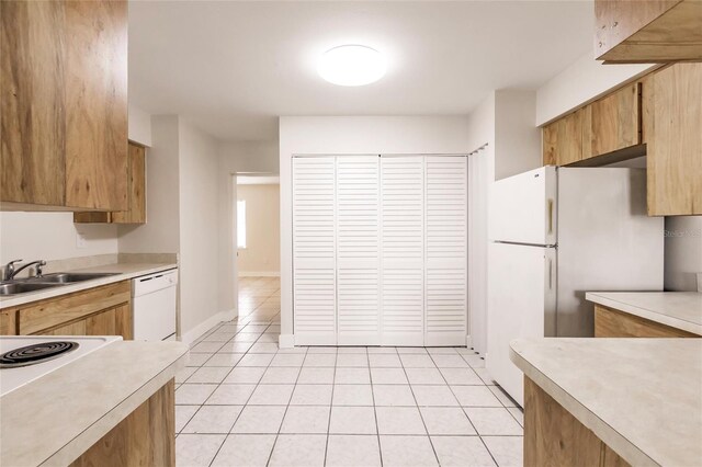 1665 Florence Ave Unit B, Englewood, FL 34223 - kitchen featuring light tile patterned floors, a sink, white appliances, and light countertops