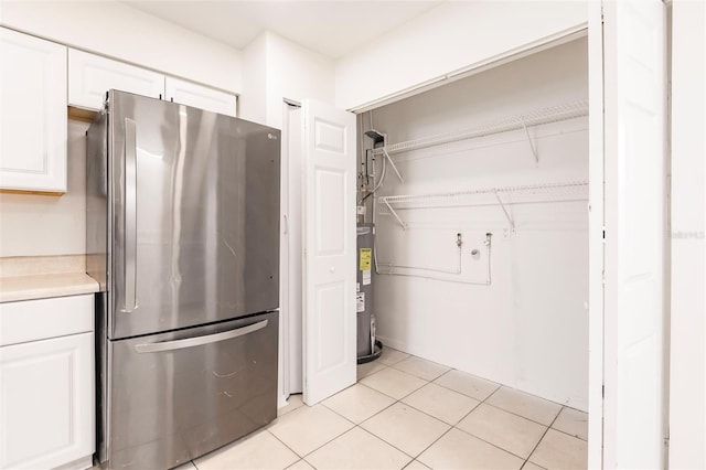 1665 Florence Ave Unit B, Englewood, FL 34223 - kitchen featuring light countertops, freestanding refrigerator, white cabinetry, and electric water heater