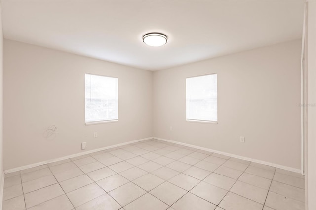 1665 Florence Ave Unit B, Englewood, FL 34223 - spare room featuring baseboards, a healthy amount of sunlight, and light tile patterned floors