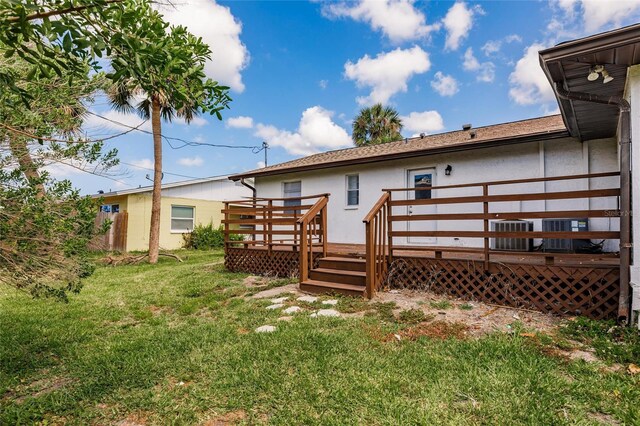 1665 Florence Ave Unit B, Englewood, FL 34223 - rear view of house featuring a wooden deck, central air condition unit, a lawn, and stucco siding