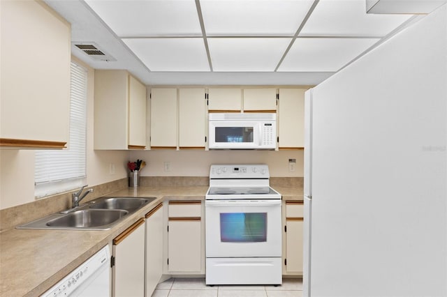 kitchen with visible vents, white appliances, light countertops, cream cabinetry, and a sink