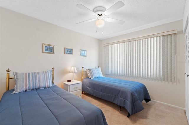 bedroom with a textured ceiling, ceiling fan, light carpet, and baseboards