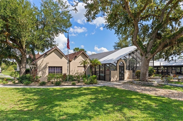 view of front of home featuring a lanai, stucco siding, and a front lawn