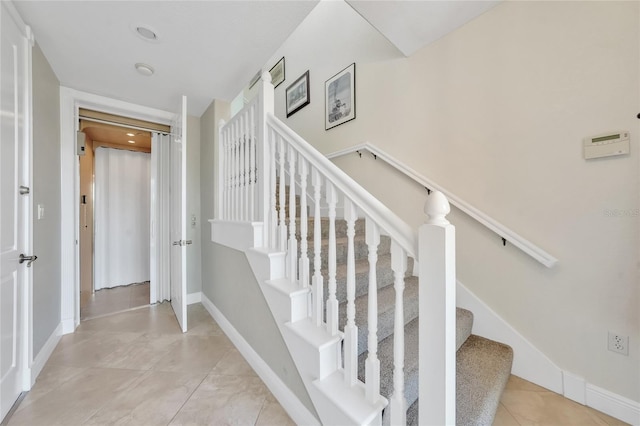 stairs with tile patterned floors and baseboards