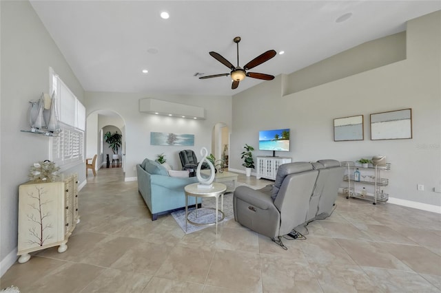 living room featuring vaulted ceiling, ceiling fan, a wall mounted air conditioner, and arched walkways
