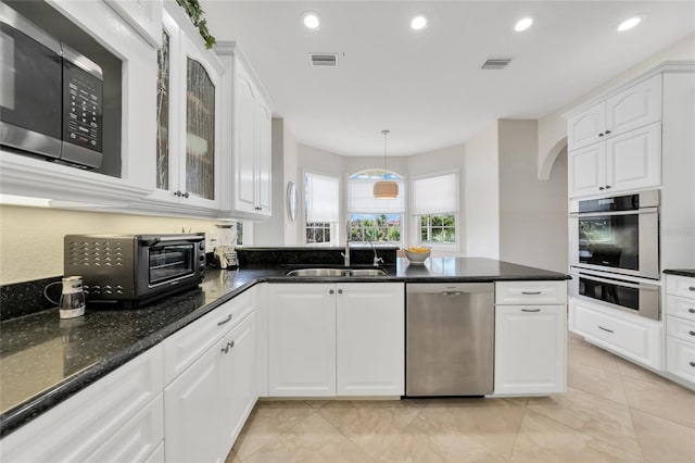 kitchen with a sink, visible vents, a toaster, white cabinetry, and appliances with stainless steel finishes