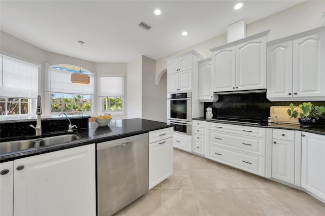 kitchen featuring a sink, stainless steel appliances, white cabinets, visible vents, and backsplash