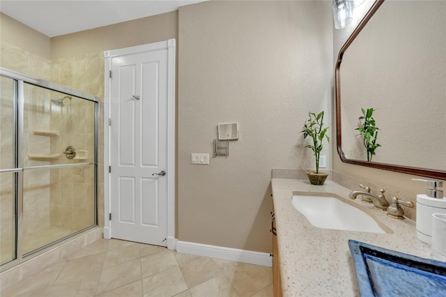 full bath featuring tile patterned floors, vanity, baseboards, and a shower stall