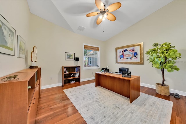 office area with a ceiling fan, baseboards, light wood finished floors, visible vents, and high vaulted ceiling