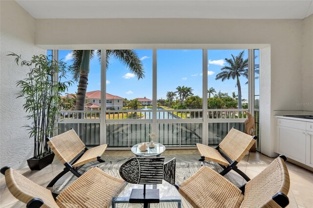 sunroom featuring plenty of natural light, a water view, and a textured wall