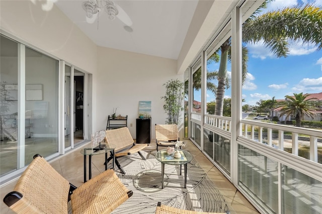 sunroom featuring tile patterned floors, ceiling fan, and high vaulted ceiling