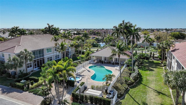 pool featuring a patio area, central AC, a residential view, a fenced backyard, and a lawn