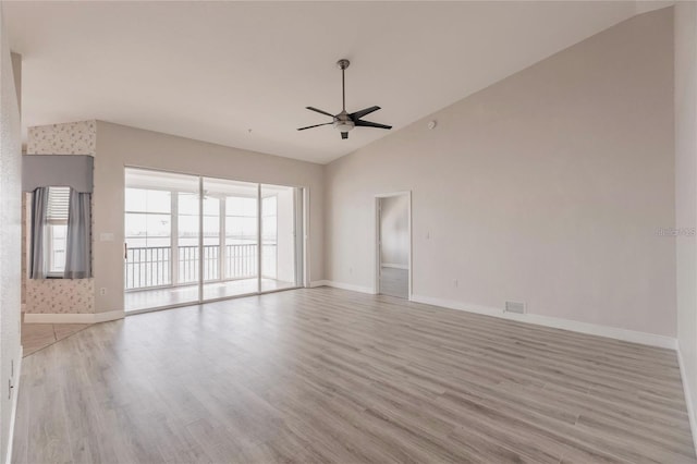unfurnished living room with vaulted ceiling, a ceiling fan, and light wood-style flooring