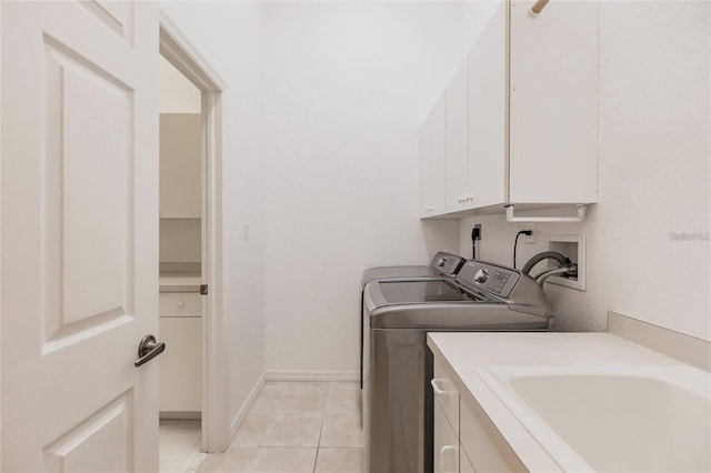 washroom featuring light tile patterned floors, a sink, independent washer and dryer, baseboards, and cabinet space