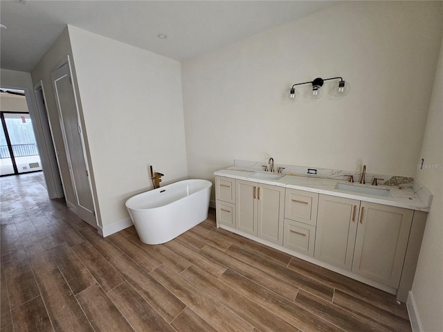 10522 Riverside Rd, Port Charlotte, FL 33981 - full bathroom with a freestanding bath, wood finished floors, double vanity, and baseboards