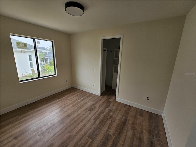 10522 Riverside Rd, Port Charlotte, FL 33981 - unfurnished bedroom featuring dark wood-style flooring, baseboards, a spacious closet, and a closet