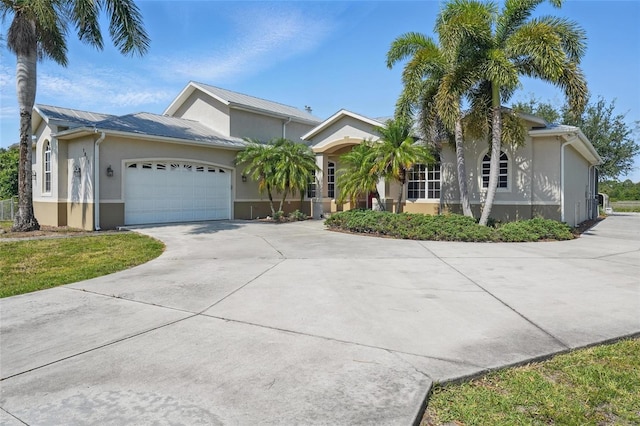 1811 Irving Ave, Lehigh Acres, FL 33972 - ranch-style house with stucco siding, concrete driveway, a garage, metal roof, and a standing seam roof