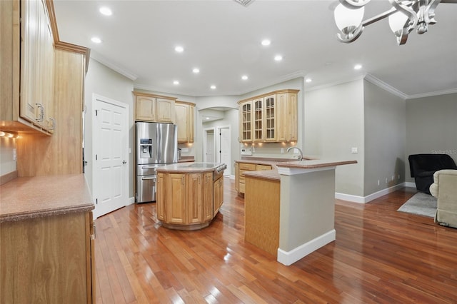 1811 Irving Ave, Lehigh Acres, FL 33972 - kitchen featuring stainless steel fridge with ice dispenser, a peninsula, ornamental molding, light wood-type flooring, and a center island