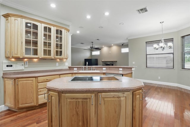 1811 Irving Ave, Lehigh Acres, FL 33972 - kitchen with black electric cooktop, a fireplace, a center island, ornamental molding, and a chandelier