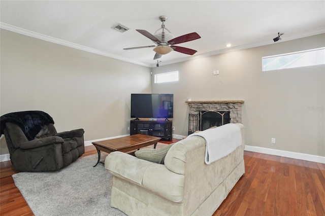 1811 Irving Ave, Lehigh Acres, FL 33972 - living room with a ceiling fan, crown molding, wood finished floors, baseboards, and a stone fireplace