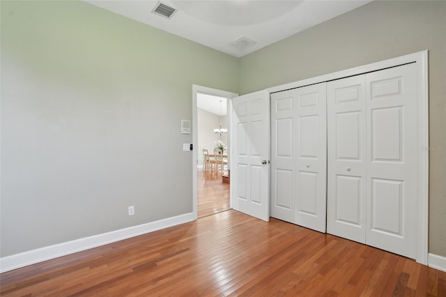 1811 Irving Ave, Lehigh Acres, FL 33972 - unfurnished bedroom with light wood-style floors, baseboards, a chandelier, and a closet