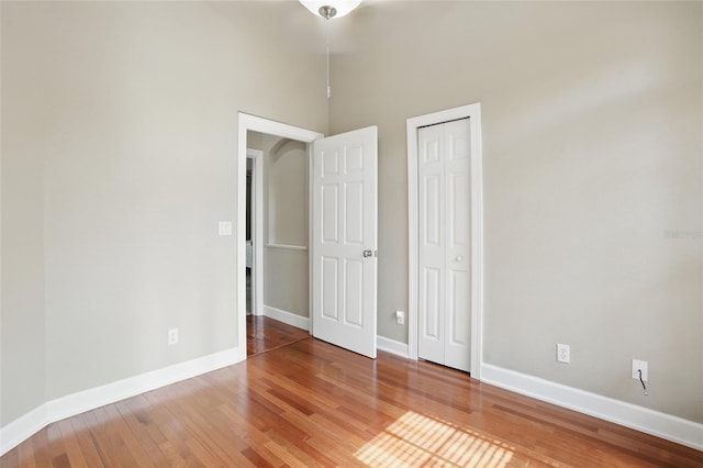 1811 Irving Ave, Lehigh Acres, FL 33972 - unfurnished bedroom with baseboards, wood finished floors, a closet, and a high ceiling