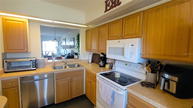 kitchen featuring light countertops, a toaster, a sink, and white appliances